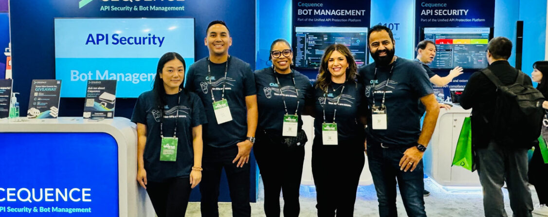 A photo of the Cequence booth staff in front of the futuristic-looking Cequence trade show booth at the Black Hat 2024 conference.