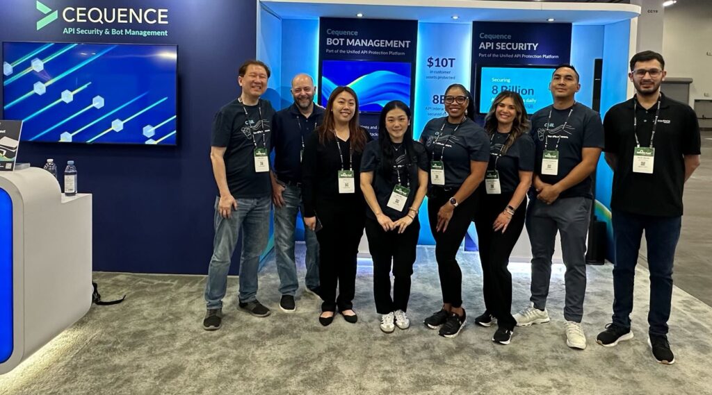 A photo of the Cequence booth staff in front of the futuristic-looking Cequence trade show booth at the Black Hat 2024 conference.